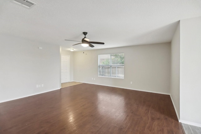 empty room with a textured ceiling and dark wood-type flooring