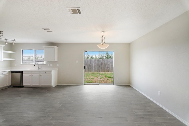 unfurnished dining area featuring a textured ceiling and light hardwood / wood-style flooring