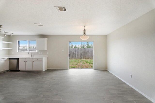 unfurnished dining area featuring a textured ceiling and light hardwood / wood-style flooring