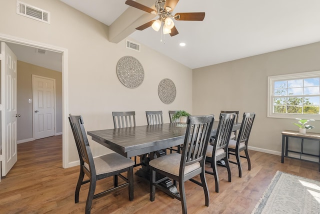 dining space featuring ceiling fan, lofted ceiling with beams, and hardwood / wood-style flooring