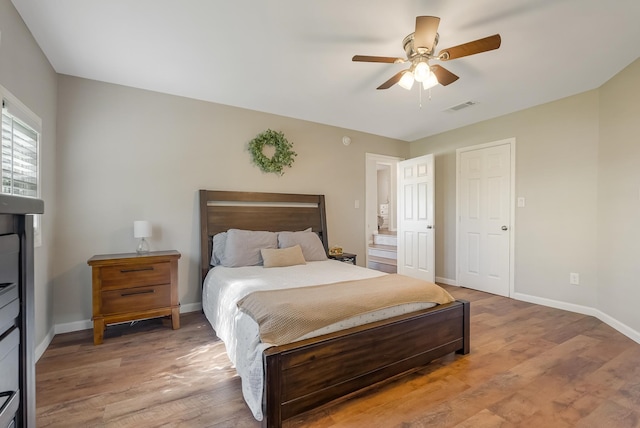 bedroom featuring ensuite bath, ceiling fan, and hardwood / wood-style flooring