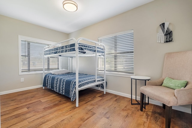 bedroom featuring wood-type flooring and multiple windows