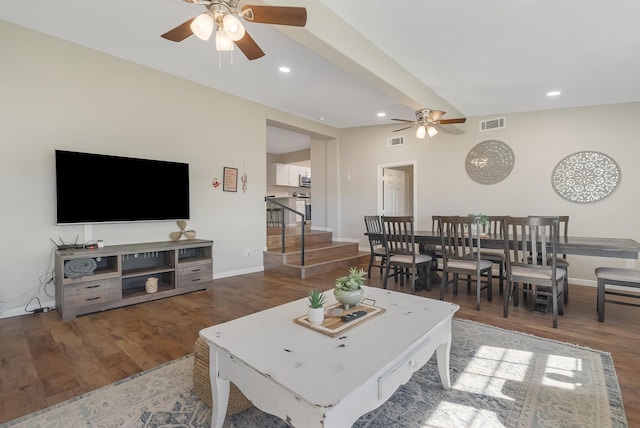 living room with ceiling fan and dark wood-type flooring