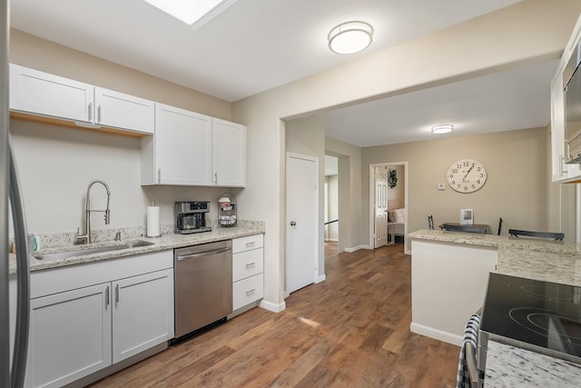 kitchen featuring hardwood / wood-style floors, white cabinetry, sink, and appliances with stainless steel finishes