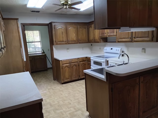 kitchen with white electric range, ceiling fan, kitchen peninsula, and light parquet floors