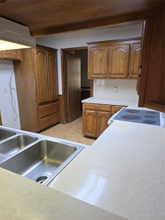 kitchen featuring sink, white electric range, and beamed ceiling