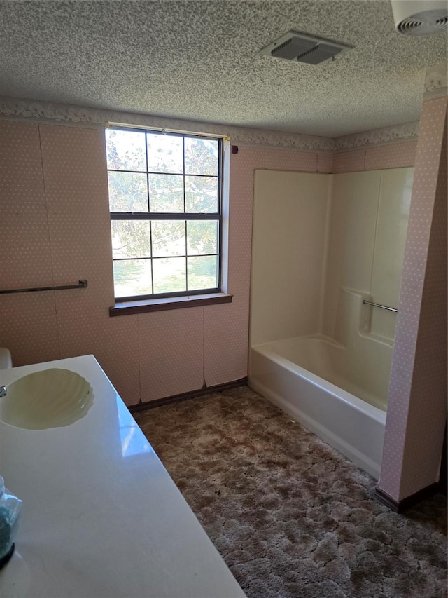 bathroom with sink, a textured ceiling, and shower / bathing tub combination