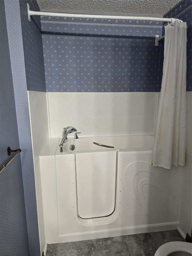 bathroom featuring a textured ceiling and tile patterned floors