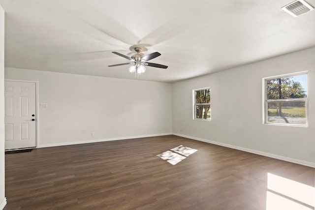 empty room featuring dark hardwood / wood-style flooring, ceiling fan, and plenty of natural light