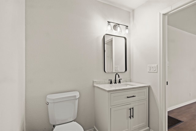 bathroom with hardwood / wood-style flooring, vanity, and toilet