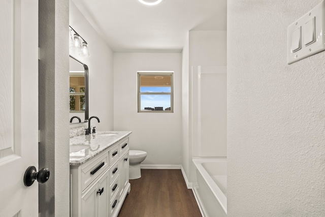 bathroom with a shower, hardwood / wood-style floors, vanity, and toilet