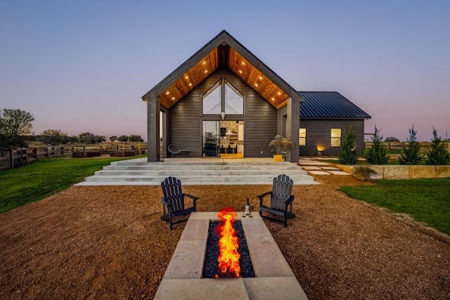 back house at dusk featuring an outdoor fire pit