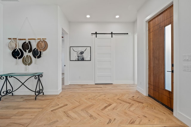 foyer entrance with a barn door and light parquet floors