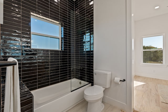 bathroom featuring toilet, wood-type flooring, and combined bath / shower with glass door