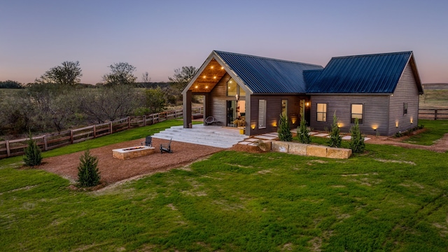 back house at dusk with a yard and a patio