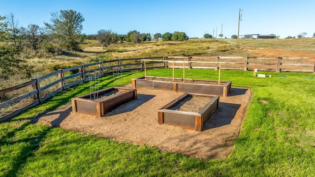 entry to storm shelter featuring a lawn and a rural view