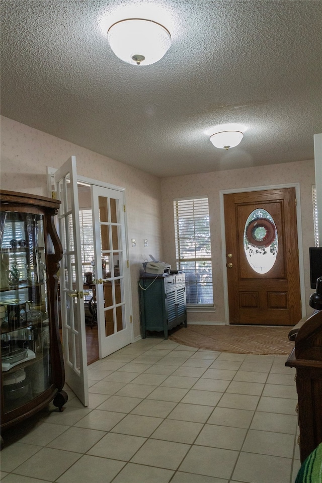 tiled foyer with a textured ceiling and french doors