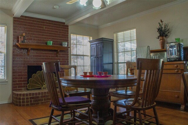 dining space featuring a fireplace, ornamental molding, beamed ceiling, and dark wood-type flooring