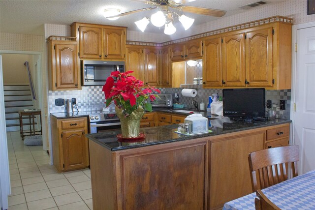 kitchen featuring kitchen peninsula, appliances with stainless steel finishes, and tasteful backsplash