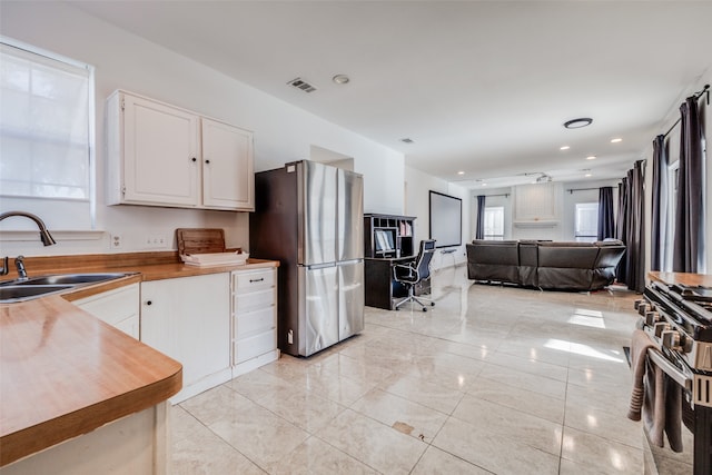 kitchen featuring white cabinets, appliances with stainless steel finishes, a healthy amount of sunlight, and sink