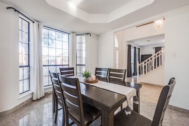 dining room featuring a tray ceiling and a chandelier