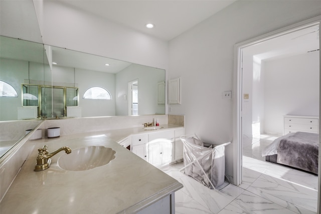 bathroom featuring a shower with door and vanity