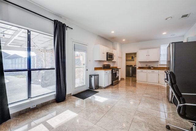 kitchen featuring a wealth of natural light, white cabinets, and appliances with stainless steel finishes