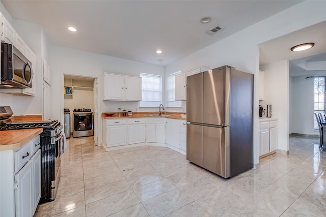 kitchen with white cabinetry, sink, stainless steel appliances, and plenty of natural light