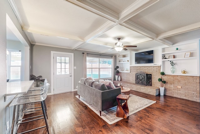 living room featuring dark hardwood / wood-style flooring, coffered ceiling, built in shelves, ceiling fan, and beamed ceiling