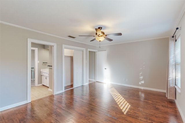 unfurnished bedroom with ceiling fan, light hardwood / wood-style floors, crown molding, and ensuite bath