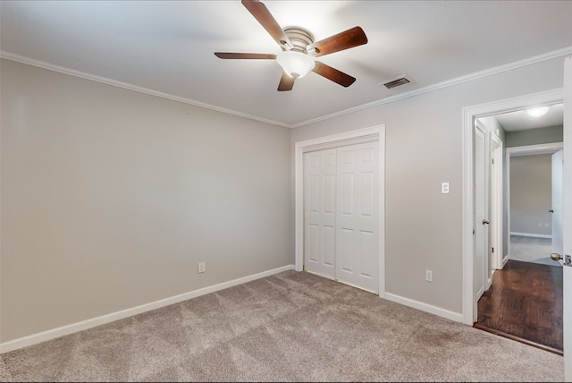 unfurnished bedroom featuring ceiling fan, crown molding, light carpet, and a closet