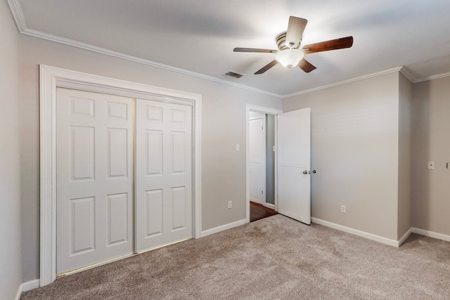 unfurnished bedroom featuring ceiling fan, light colored carpet, ornamental molding, and a closet