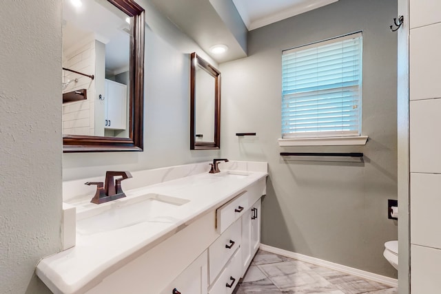 bathroom featuring toilet, vanity, and ornamental molding