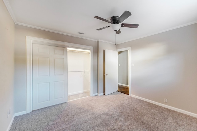 unfurnished bedroom with ceiling fan, carpet floors, ornamental molding, and a closet