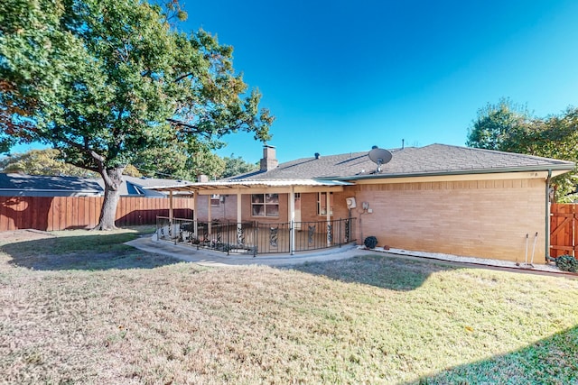 rear view of property featuring a yard