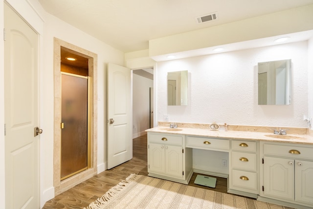 bathroom featuring vanity, wood-type flooring, and walk in shower