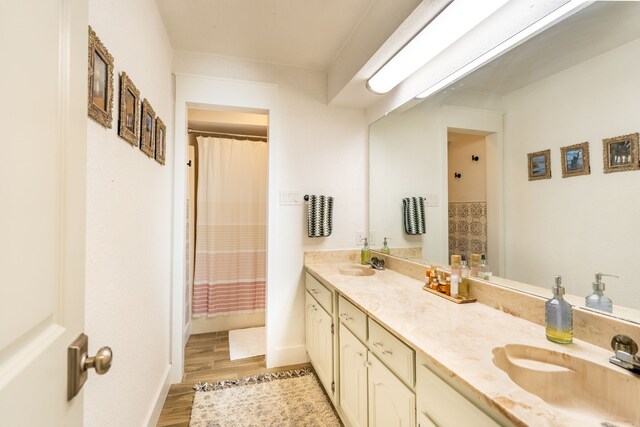 bathroom featuring walk in shower, vanity, and hardwood / wood-style flooring