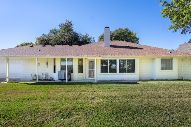 rear view of property featuring a yard and a patio area