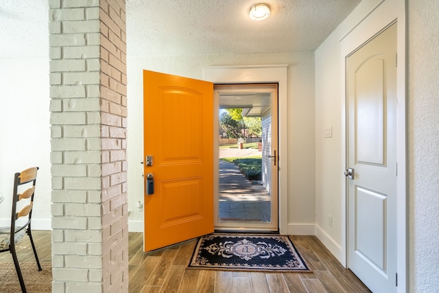 entrance foyer featuring a textured ceiling and dark wood-type flooring