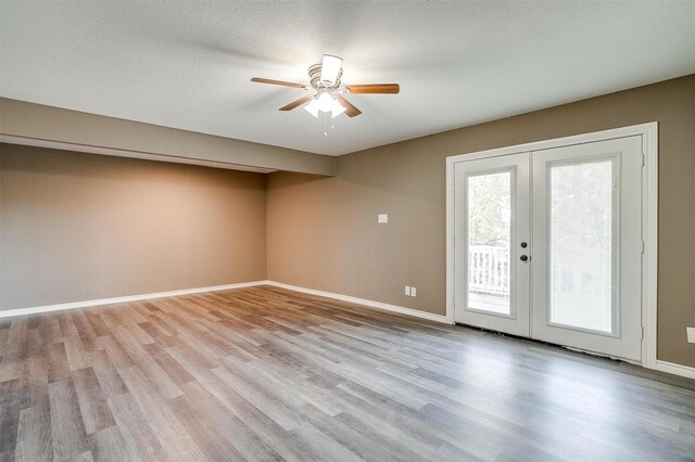 unfurnished room featuring ceiling fan, light hardwood / wood-style floors, a textured ceiling, and french doors