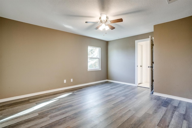 spare room featuring ceiling fan, wood-type flooring, and a textured ceiling