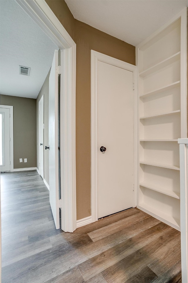 corridor featuring hardwood / wood-style floors and a textured ceiling