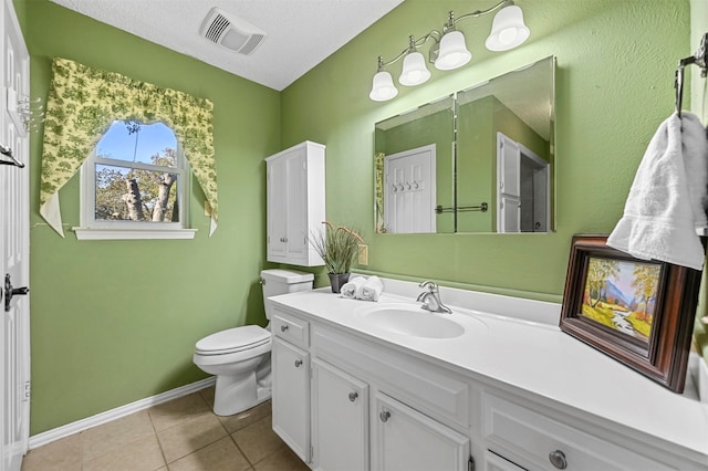 bathroom featuring toilet, a textured ceiling, vanity, and tile patterned floors