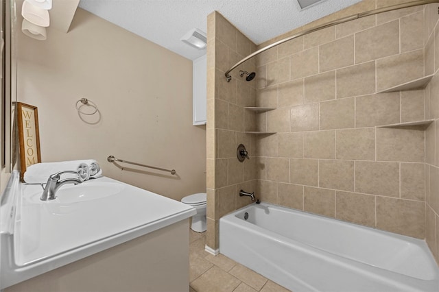 full bathroom featuring vanity, tiled shower / bath, tile patterned flooring, toilet, and a textured ceiling