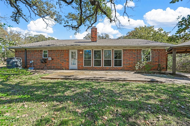 rear view of house featuring a lawn and a patio area