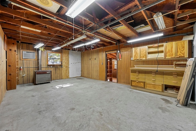 basement featuring a wall unit AC and wooden walls