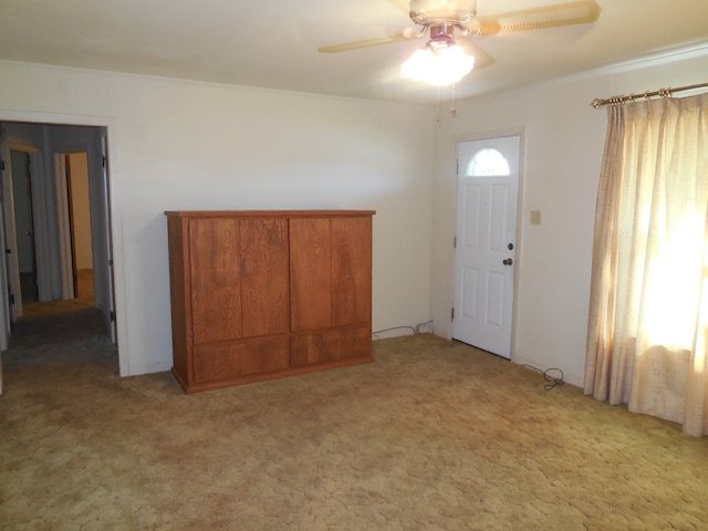 entryway with ceiling fan and light carpet