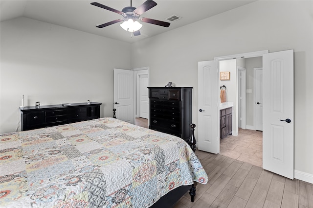 bedroom featuring ensuite bath, ceiling fan, light hardwood / wood-style floors, and lofted ceiling