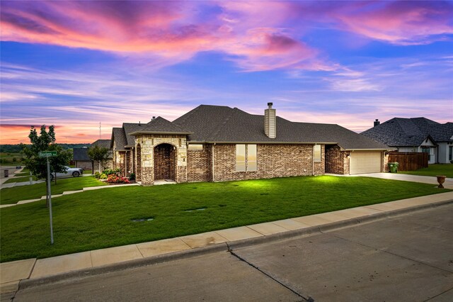 view of front of property featuring a lawn and a garage