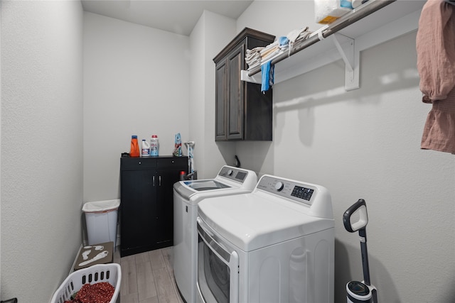 washroom with cabinets, independent washer and dryer, and light hardwood / wood-style flooring